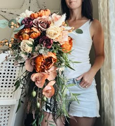 a woman holding a bouquet of flowers in her hands