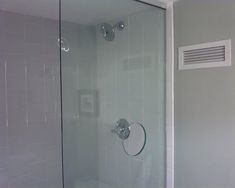 a glass shower door in a white bathroom