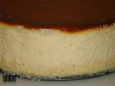 a cheesecake covered in caramel sauce on a white plate with a black border