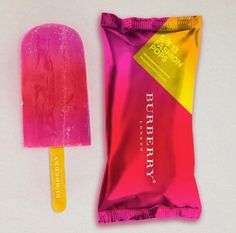 a pink and yellow popsicle next to a bag of raspberry ice cream