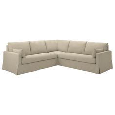 a beige sectional couch with pillows on the top and bottom corner, facing away from the camera