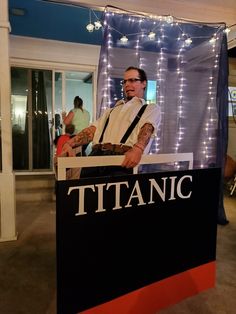 a man standing behind a sign that says titanic