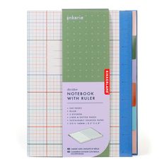 a notebook with rulers on the side and two different colored papers in front of it