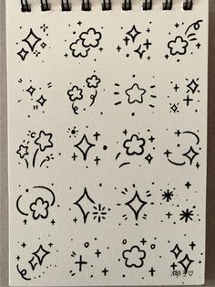 a notebook with black ink on it and stars, clouds, and moon symbols in the middle