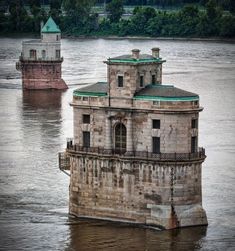 an old building sitting on top of a river next to another one in the water