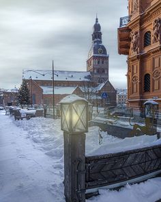 a street light in the middle of a snowy city