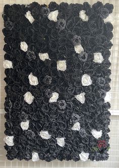 black and white roses are arranged on the wall