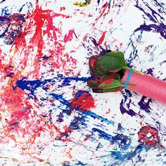 a painting with paint splattered all over it and a pink tube sticking out of the middle