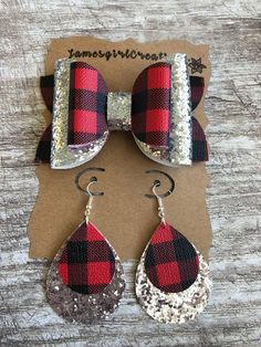 red and black plaid bowknots with silver glitter tear drop earrings sitting on top of a piece of cardboard