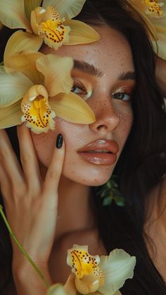 a woman with flowers in her hair posing for the camera and holding her hands up to her face