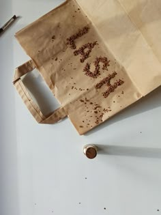 a paper bag with writing on it next to a pen