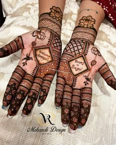 two hands with henna designs on them, one is showing the words and the other has