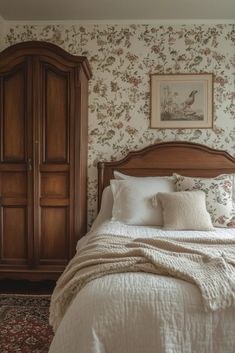 a bed sitting in a bedroom next to a wooden dresser and armoire on top of a carpeted floor