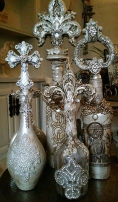 ornate silver vases and other decorative items on a table in front of a mirror