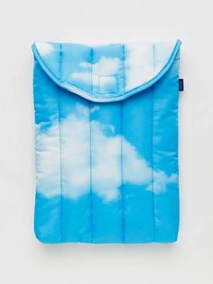 a blue and white bag with clouds in the sky on it's front pocket