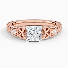 a rose gold engagement ring with a princess cut diamond in the center and side stones