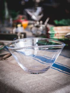 a glass bowl sitting on top of a table next to other dishes and utensils