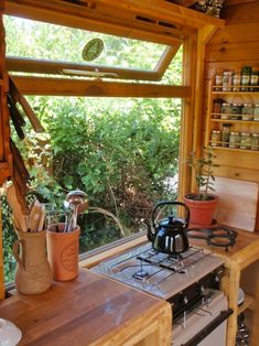 a stove top oven sitting inside of a kitchen next to a wooden counter and window