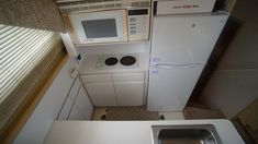 an overhead view of a small kitchen with white appliances