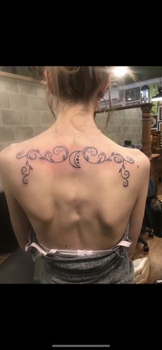 the back of a woman's neck with an ornamental design on her left side