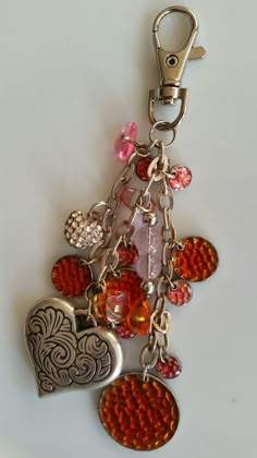 a key chain with several charms attached to it's sides and two hearts on each side