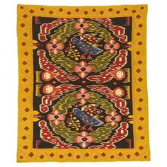 an old rug with colorful designs on the front and back side, in yellow and black colors