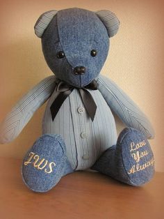 a blue teddy bear sitting on top of a wooden table next to a brown wall