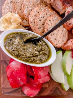 an assortment of food on a cutting board with a knife and fork in the bowl