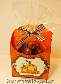 an orange box filled with candies wrapped in cellophane and tied with a bow