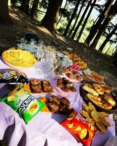 a picnic table with snacks and drinks on it