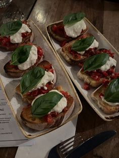 two trays filled with food sitting on top of a wooden table