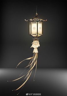 a lantern hanging from the ceiling with long streamers on it's sides and an intricately decorated handle