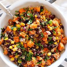 a white bowl filled with black beans, corn and quinoa salad on top of a checkered table cloth