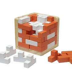 an orange and white blocky puzzle is shown in front of several smaller cubes