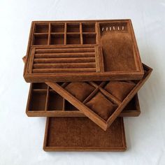 three wooden boxes with compartments and dividers on top of each other, one is empty