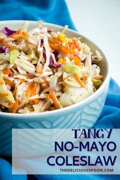 a white bowl filled with coleslaw salad on top of a blue cloth next to a fork