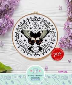 a cross stitch pattern with a butterfly on it and some purple flowers in the background