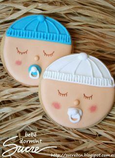 two decorated cookies sitting on top of a basket next to each other with eyes closed