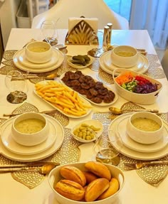 a table set with plates and bowls filled with food