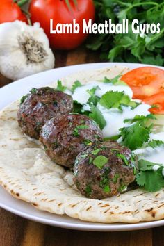 some meatballs are sitting on a tortilla with sour cream and garnish