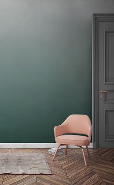 a pink chair sitting in front of a green wall with an open door to another room