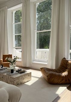 a living room filled with furniture and large windows