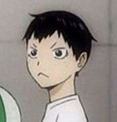 an anime character with black hair and green eyes looking at something in front of him