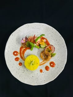 a white plate topped with food on top of a black table next to a knife and fork