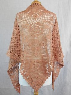 an orange crocheted shawl on a mannequin