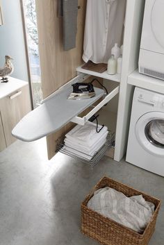 an ironing board is sitting on the shelf next to a washer and dryer