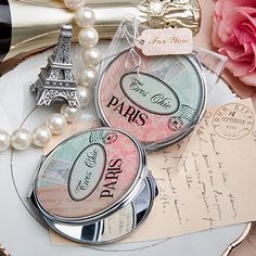 two compact mirrors with the words paris and eiffel tower in pink, green, blue