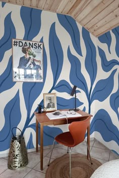 a blue and white wall with an animal print design on it, next to a red chair