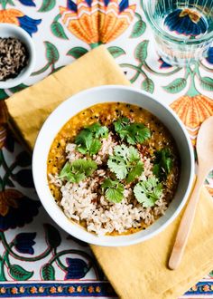 a white bowl filled with rice and cilantro on top of a yellow napkin