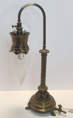 an old fashioned lamp with a glass shade on it's top and a key to the bottom